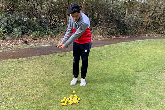 Junior golfer having a green-side chipping lesson.